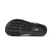 The bottom of a black running shoe on a white background