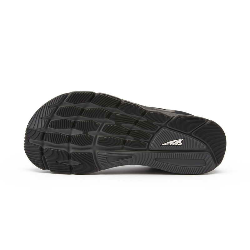 The bottom of a black running shoe on a white background