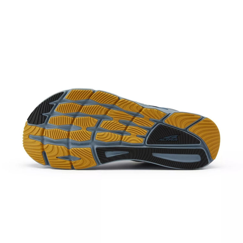 A blue a black running shoe with a yellow bottom on a white background