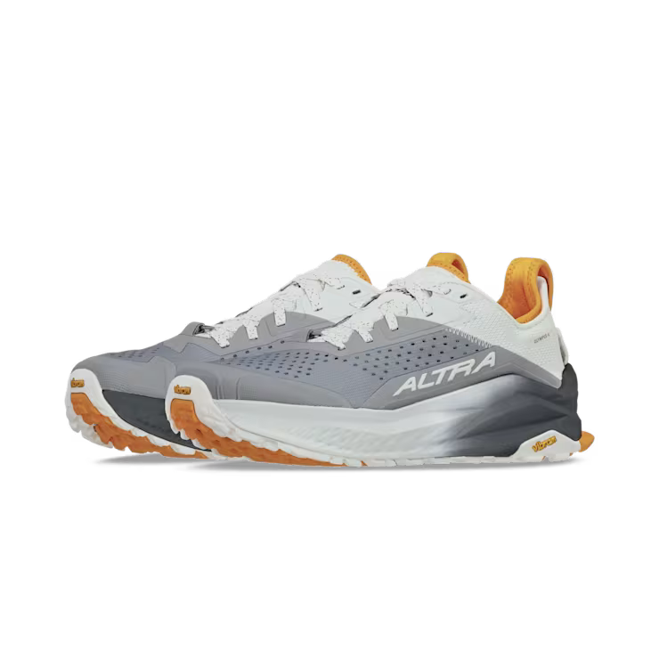 Side view of a pair of gray hiking shoes with orange and white accents against a white background. 