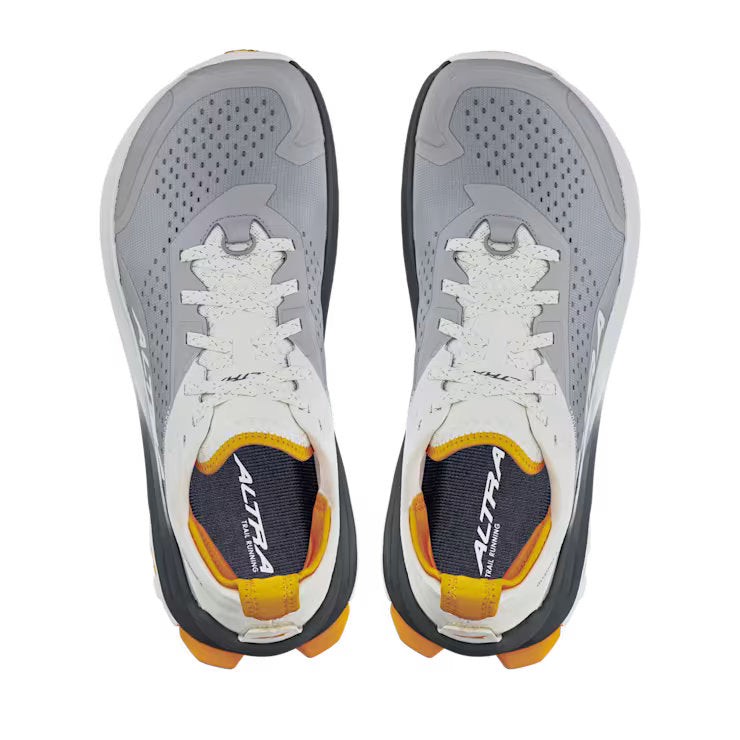 Top view of a pair of grey hiking shoes with white and orange accents against a white background. 