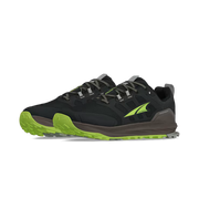 Side view of a pair of black hiking shoes with lime green accents against a white background. 