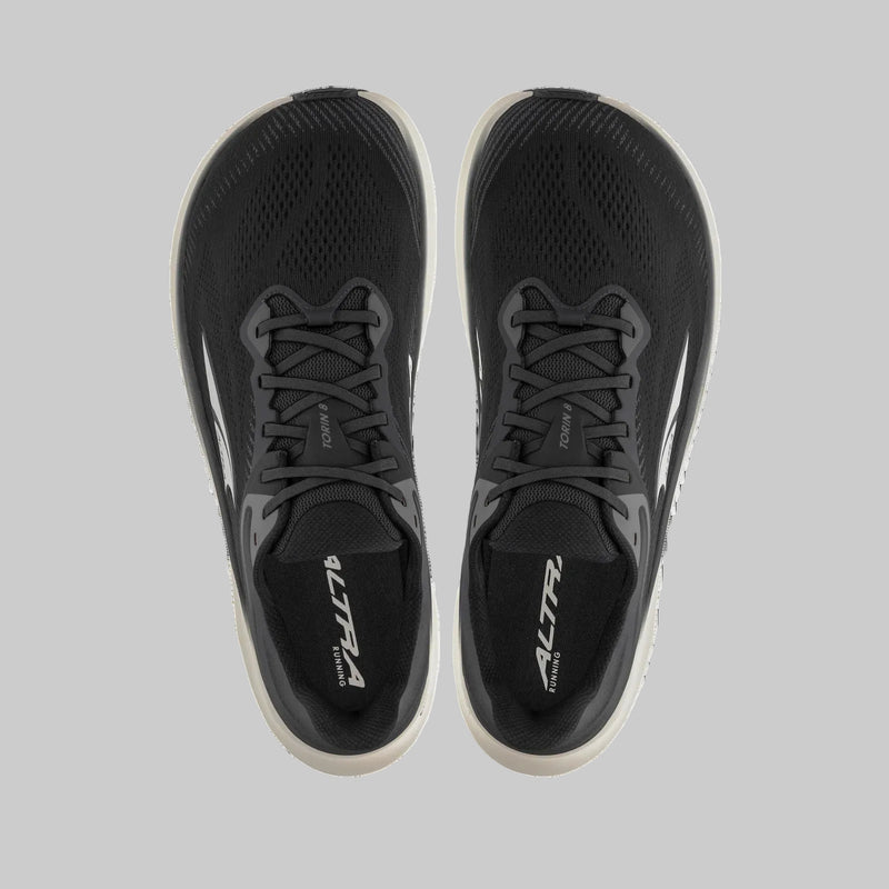A pair of black running shoes from above on a white background