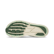 The bottom of a green running shoe on a white background