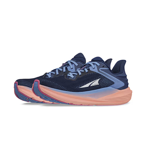 Side view of a pair of navy blue trail running shoes with pink accents and blue laces against a white background. 