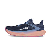 Side view of a navy blue trail running shoe with pink accents and blue laces against a white background.