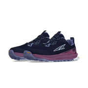 Side view of a pair of navy blue colored trail running shoes with purple accents against a white background. 