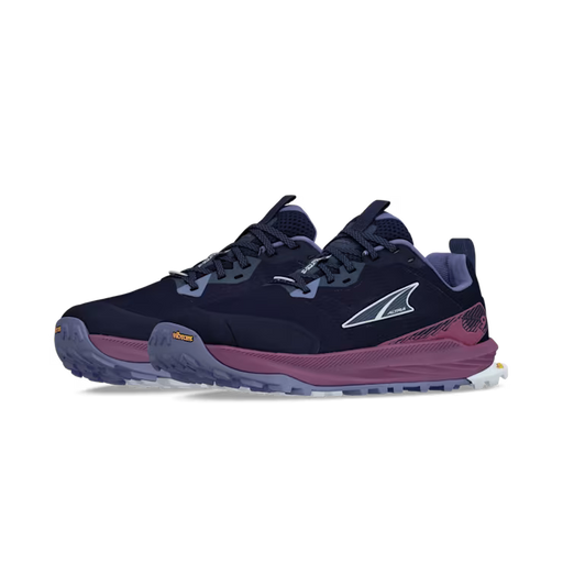 Side view of a pair of navy blue colored trail running shoes with purple accents against a white background. 