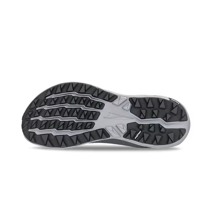 View of the bottom tread of a grey trail running shoe against a white background. 