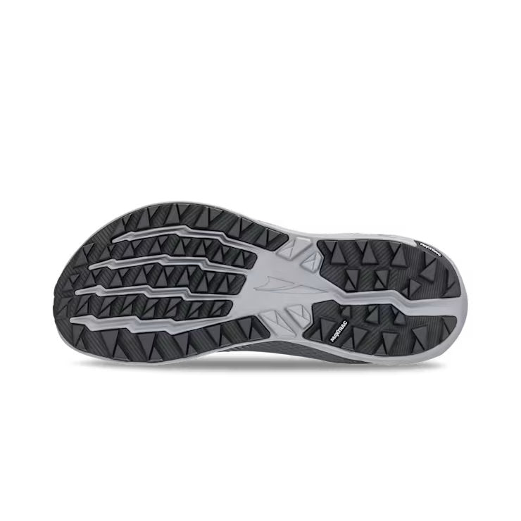 View of the bottom tread of a grey trail running shoe against a white background. 