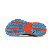 View of the bottom tread of a red and orange trail running shoe against a white background. 