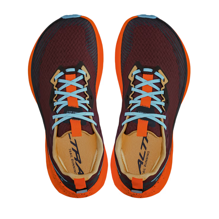 Top view of a pair of red shoes with orange accents and blue laces against a white background. 