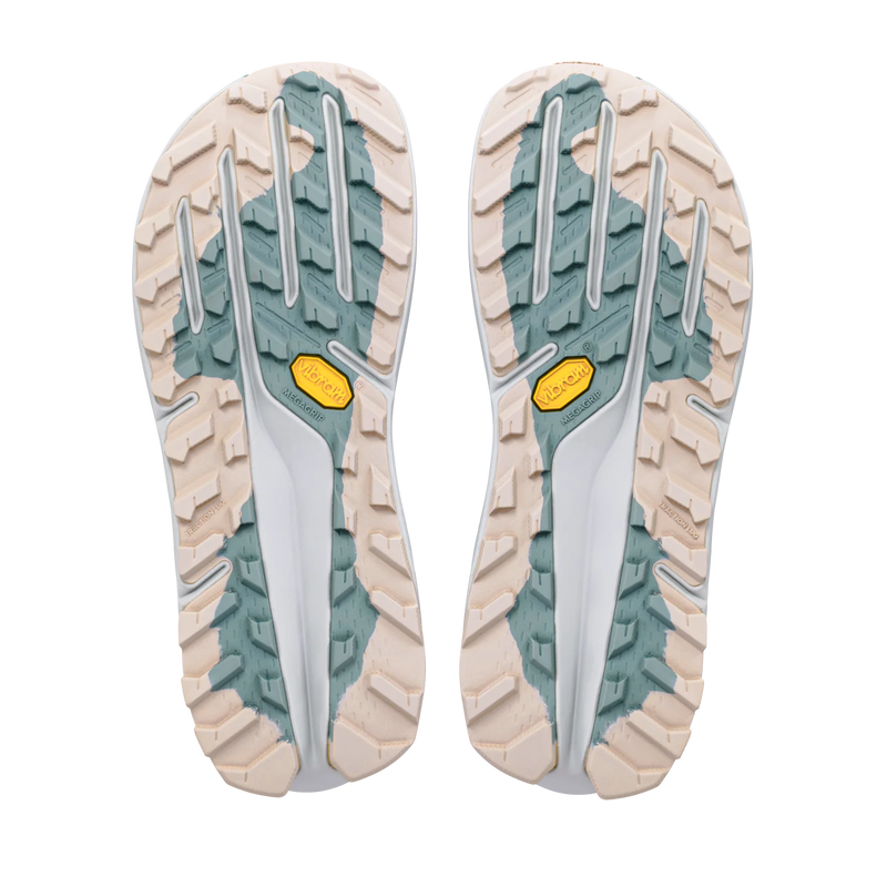 The soles of a pair of trail running shoes, showing a beige and white tread pattern with sage green accents and yellow Vibram logos.