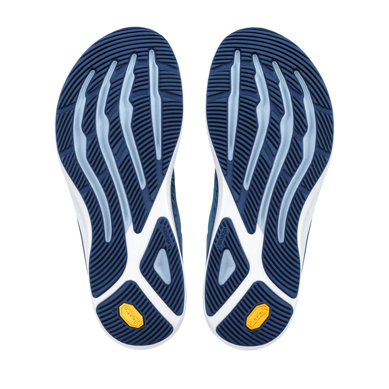 The bottoms of a pair of light blue running shoes on a white background