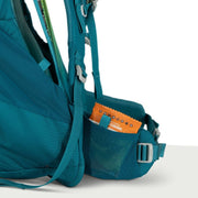A blue hiking backpack holding a bag of snacks on a white background