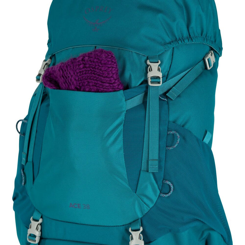 A blue hiking backpack holding a purple knitted piece on a white background