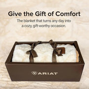 White blanket with brown ribbons in a box, Ariat logo visible, text 'Give the Gift of Comfort'.