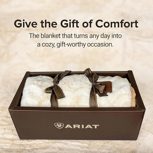 White blanket with brown ribbons in a box, Ariat logo visible, text 'Give the Gift of Comfort'.