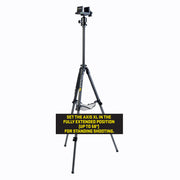 A black tripod standing on a white background with a black instruction label overlaid near the bottom. The label reads: 'SET THE AXIS XL IN THE FULLY EXTENDED POSITION (UP TO 56") FOR STANDING SHOOTING.