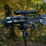 Crossbow with scope on a stand against a blurred natural background