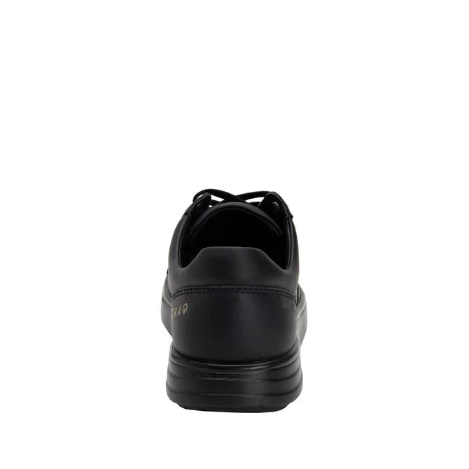 Back view of a completely black shoe against a white background. 
