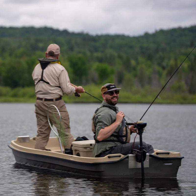 Two happy men in a brown and tan fishing boat on a lake with fishing poles. 