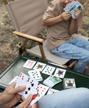 People playing a deck of cards that have wildlife and animal prints on them. 