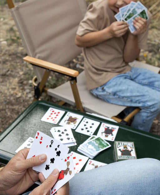 People playing a deck of cards that have wildlife and animal prints on them. 