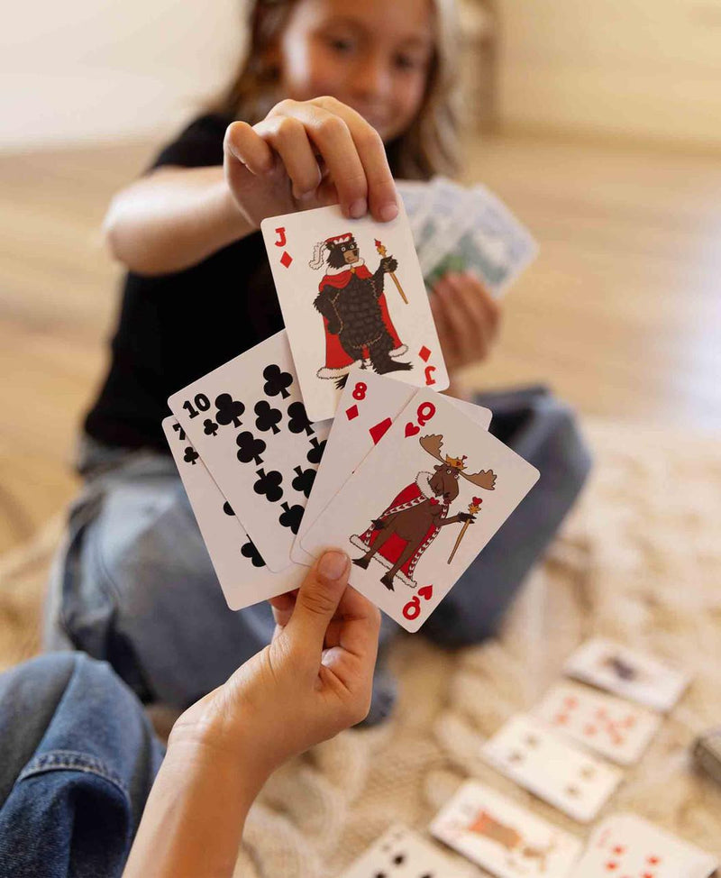 Kids playing with a deck of cards that have wildlife and animal prints on them. 