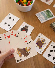 Hand holding a deck of cards with wildlife and animal prints on them.
