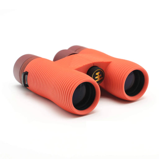 A bright orange pair of binoculars with a maroon dial on a white background