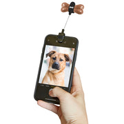 Person holding a phone with a dog accessory at the top looking at a cute photo of a dog against a white background. 