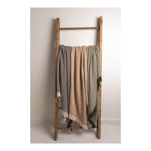 Tri-colored throw blanket featuring blue, tan, and green hanging on a wooden rack. 