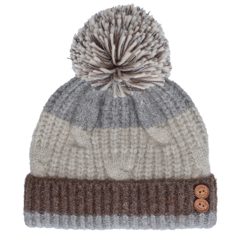 grey pom pom beanie with brown accents against a white background. 