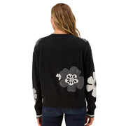 Black sweater with floral patterns on a plain background