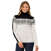 Woman wearing a black and white patterned sweater on a plain background