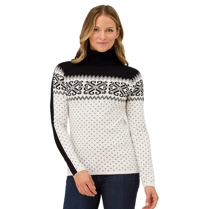 Woman wearing a black and white patterned sweater on a plain background