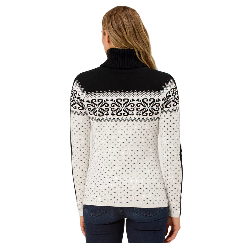 Woman wearing a black and white patterned sweater on a plain background