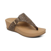 Side facing view of a tan wedge sandal with a brown strap and gold colored buckle against a white background. 