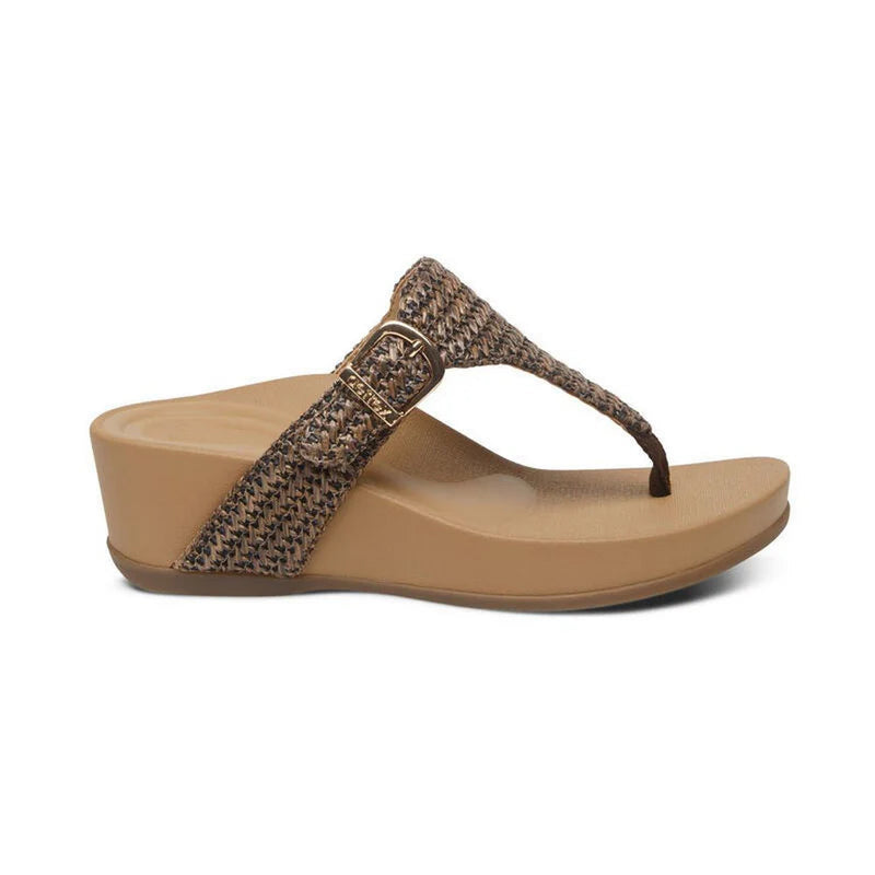 Side facing view of a tan sandal with a brown strap and gold colored buckle against a white background. 