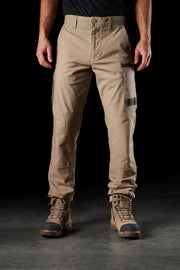 Person wearing tan pants and brown boots on a black background