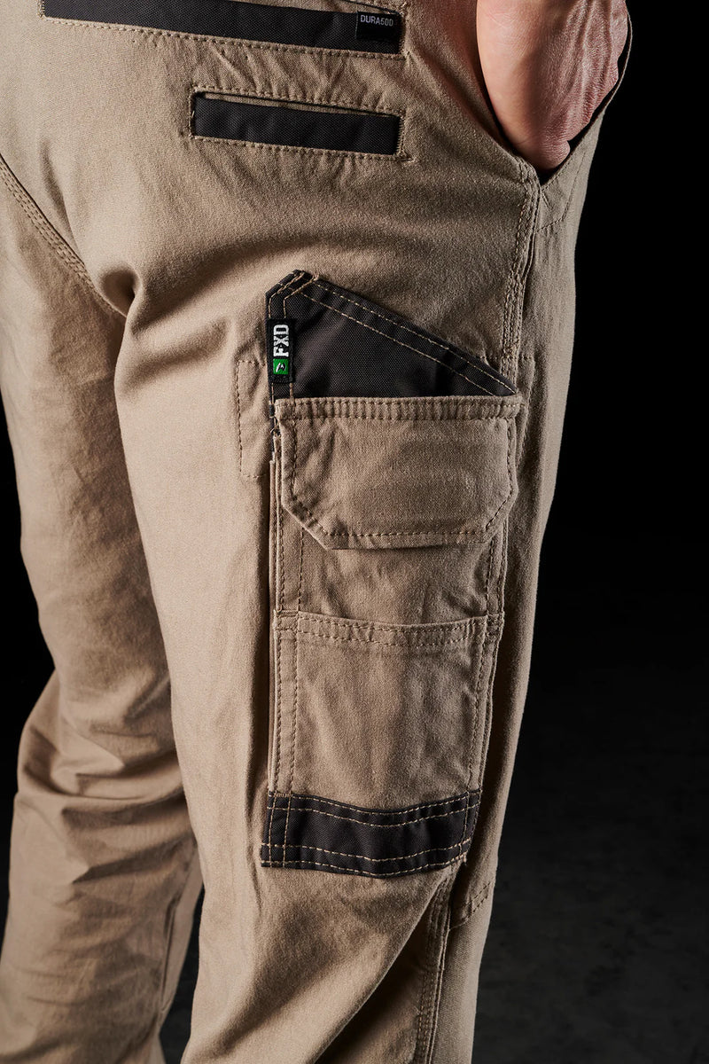 Close-up of beige cargo pants with multiple pockets on a black background