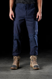 Person wearing navy pants and brown boots on a dark background