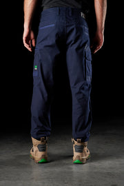 Person wearing navy cargo pants with a black background