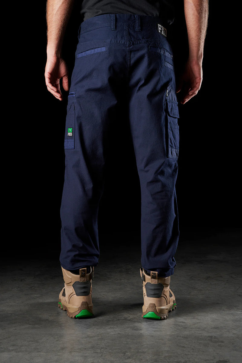 Person wearing navy cargo pants with a black background