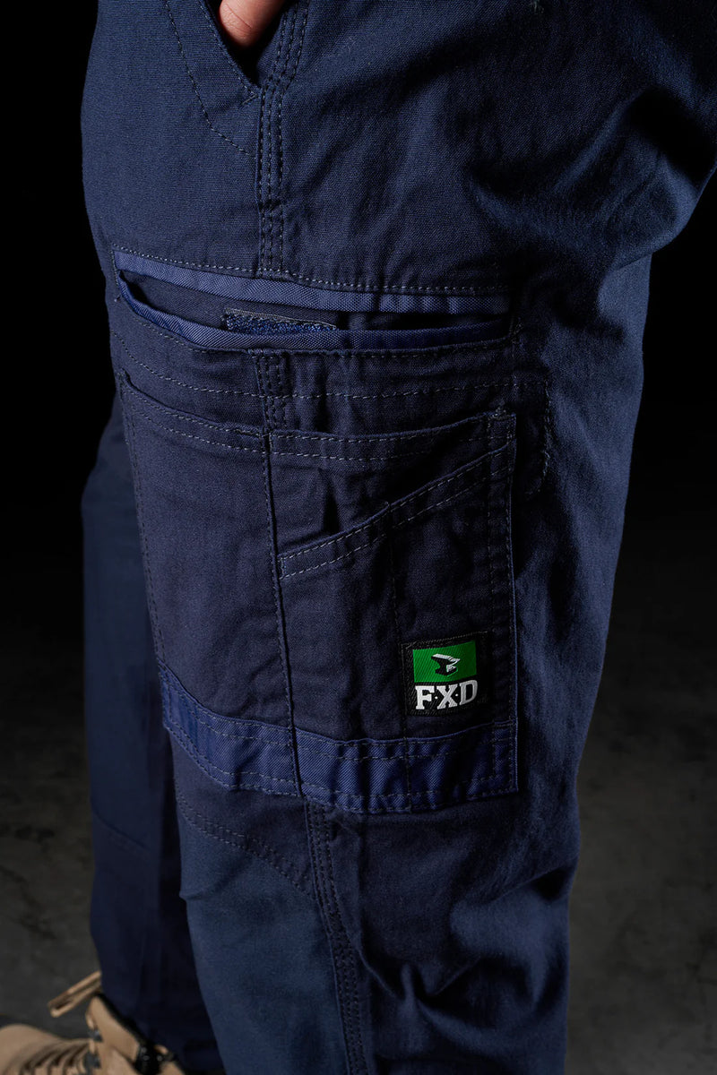 Navy blue work pants with a visible FXD logo on a dark background
