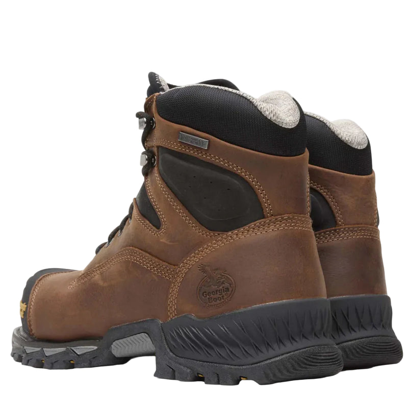 Pair of brown work boots with black soles on a white background