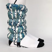 Side view of a model wearing white and blue gaiters against a white background. 