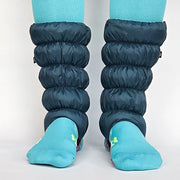 Blue leg warmers over teal socks on a plain background