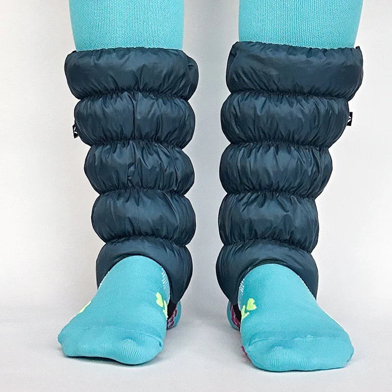 Blue leg warmers over teal socks on a plain background